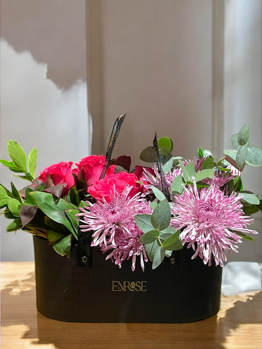 Arranjo Luxuoso em Bolsa Preta com Rosas Vermelhas e Flores Exóticas